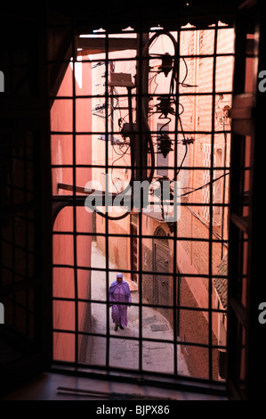 Signora marocchina percorrendo a piedi una stradina nella medina di Marrakech Foto Stock