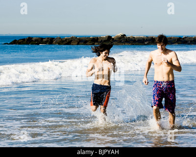 Due uomini in esecuzione sulla spiaggia Foto Stock