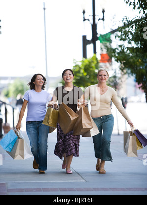 Tre ragazza amici saltando giù per la strada Foto Stock