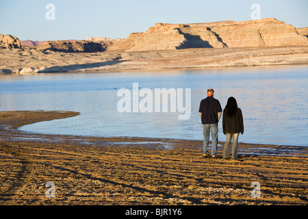 Giovane camminando lungo la riva del lago Powell, vicino a Utah e Arizona linea di stato. Caucasico maschio, femmina discesa asiatica. Foto Stock