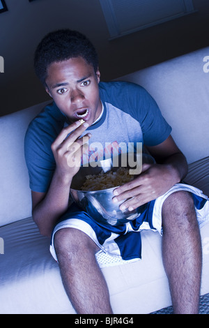 Ragazzo adolescente mangiare popcorn Foto Stock