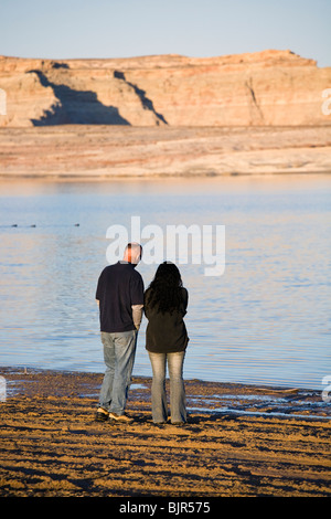 Giovane camminando lungo la riva del lago Powell, vicino a Utah e Arizona linea di stato. Caucasico maschio, femmina discesa asiatica. Foto Stock