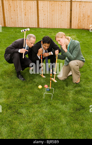 Tre uomini d'affari giocando croquet Foto Stock