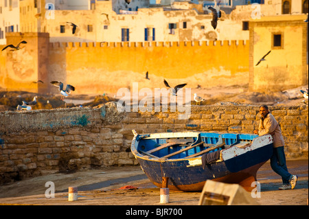 Si tratta di un immagine di un uomo marocchino in appoggio su una barca da pesca a Essaouira. Foto Stock