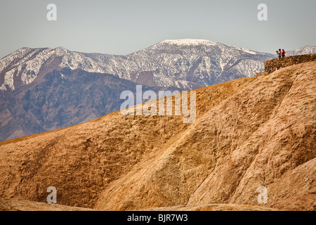 Turisti alla scenic si affacciano al badlands a Zabriskie Point guardando verso il Golden Canyon nel Parco Nazionale della Valle della Morte Foto Stock