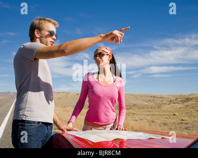 L uomo e la donna accanto a un rosso convertibili Foto Stock
