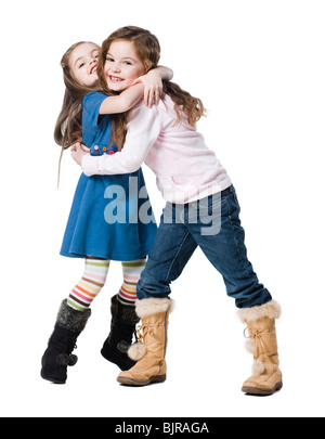 Ritratto in studio di due ragazze (4-7) abbracciando Foto Stock