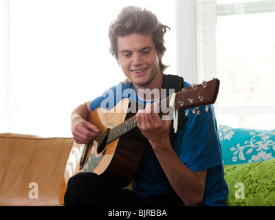 Stati Uniti d'America, Utah, Provo, giovane a suonare la chitarra in salotto