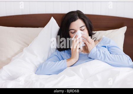 Stati Uniti d'America, Utah, Orem, giovane donna starnuti a letto Foto Stock