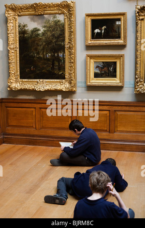 Scolari i visitatori alla Dulwich Picture Gallery apprezzare la peste incorniciato dipinti sulle pareti. Foto Stock