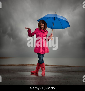 Stati Uniti d'America, Utah, Orem, donna con ombrello in piedi in una pozza Foto Stock