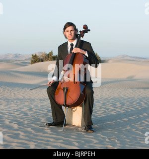 Stati Uniti d'America, Utah, Little Sahara, Ritratto di giovane con violoncello nel deserto Foto Stock
