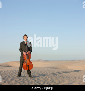 Stati Uniti d'America, Utah, Little Sahara, Ritratto di giovane con violoncello nel deserto Foto Stock