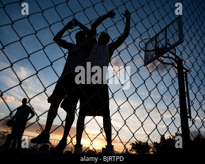 Stati Uniti d'America, Utah, Salt Lake City, tre giovani uomini giocando street basketball, basso angolo di visione Foto Stock