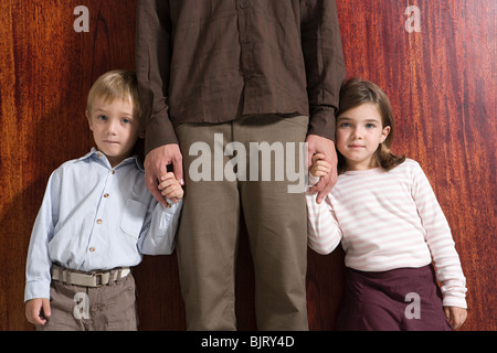 I bambini tenendo i loro padri mano Foto Stock