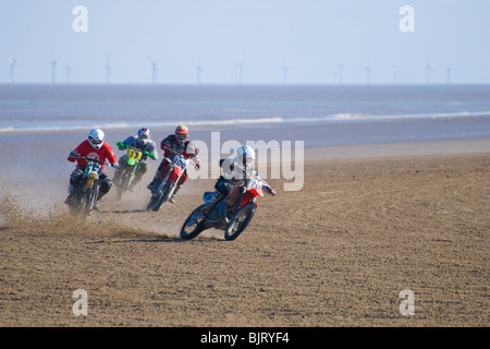 Moto Racing di sabbia sulla spiaggia con le turbine eoliche in background sul mare, Mablethorpe, Lincolnshire, England, Regno Unito Foto Stock