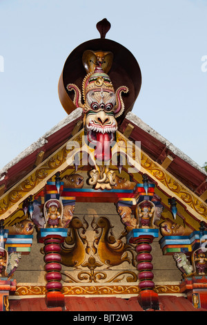 India Kerala, Cannanore (Kannur), serpent motif, intagliato e dipinto figure in legno sopra la porta del tempio Foto Stock