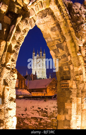 Gloucester Cattedrale al crepuscolo visto attraverso un arco nelle rovine del St Oswalds Priory in una serata d'inverni - Gloucester UK Foto Stock