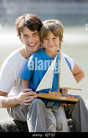 Padre e Figlio con barca giocattolo Foto Stock