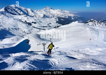 Uno sciatore set off verso il basso dalla parte superiore della Luegli eseguire, Adelboden. Con vedute di Silleren. Foto Stock