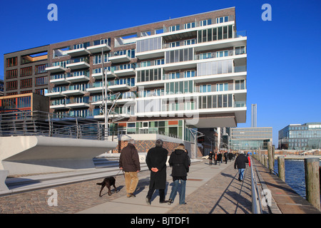 Passanti a piedi nella parte anteriore di nuova costruzione di edifici nel Quartier Dallmannkai district, Amburgo, Germania Foto Stock