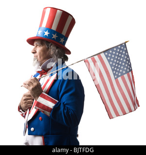 Uomo in lo zio Sam costume di holding bandiera americana, studio shot Foto Stock