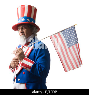 Uomo in lo zio Sam costume di holding bandiera americana, studio shot Foto Stock