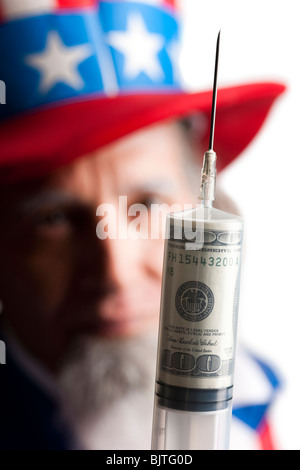 Uomo in lo zio Sam costume tenendo la siringa con il dollaro USA all'interno di banconote, studio shot Foto Stock