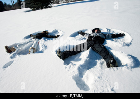 Giovane rendendo gli angeli di neve Foto Stock