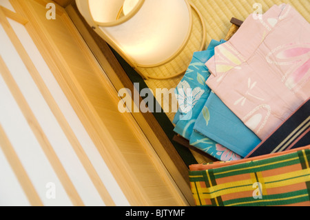 Yukata piegati accanto a una lanterna in una camera giapponese Foto Stock