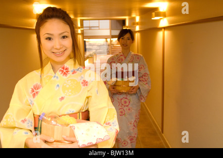 Due donne che indossano yukata a piedi attraverso il corridoio di un health spa Foto Stock