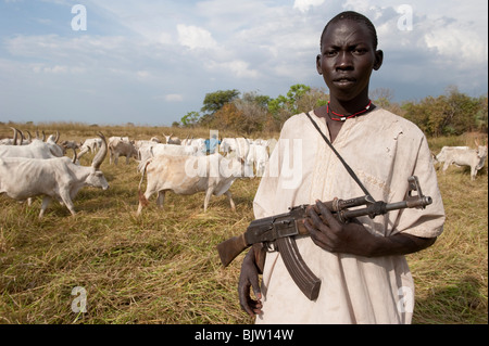 Del sud-Sudan, Cuibet vicino a Rumbek , tribù Dinka, pastore armati con Kalashnikov AK-47 proteggere i loro zebù vacche da bovini ostile raider Foto Stock