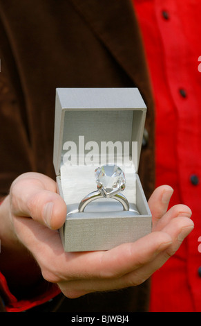 Uomo in possesso di una scatola con un grande diamante anello di aggancio all'interno. Foto Stock