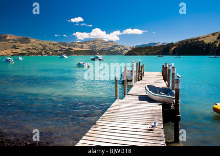 Barca sul molo di porto, Akaroa, Nuova Zelanda Foto Stock