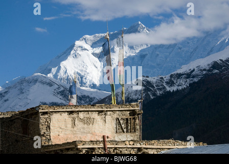 Annapurna 2, altitudine 7937 m di altitudine, sopra le case di pietra con la preghiera le bandiere, Manang, Circuito di Annapurna, Nepal Foto Stock