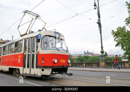 Castello di Praga con tram Tatra T3 in primo piano Praga Repubblica Ceca | PRAGA, Repubblica Ceca - Un tram Tatra T3 rosso e color crema, n. 7232 sulla rotta 9, attraversa il Ponte della Legione con il Castello di Praga che si innalza sopra la Moldava in lontananza. Progettato da František Kardaus e introdotto in servizio a Praga nel 1962, il Tatra T3 rimane un simbolo duraturo della rete tranviaria della città, ancora in esecuzione decenni dopo il debutto del modello nell'ex blocco orientale. Foto Stock
