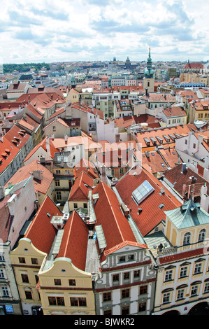 Tetti della città vecchia dalla Torre del Municipio della città Vecchia di Praga Repubblica Ceca // PRAGA, Repubblica Ceca - Una vista dalla Torre del Municipio della città Vecchia si affaccia sui tetti densi di tegole rosse della città Vecchia di Praga (Staré Město). La torre gotica, situata sulla Piazza della città Vecchia (Staroměstské náměstí), offre viste panoramiche dalla sua galleria di osservazione alta quasi 70 metri (230 piedi). La scena cattura la ricca miscela architettonica del quartiere, con edifici risalenti al periodo romanico, gotico e barocco. Tra le strutture storiche è visibile la guglia della chiesa di San Giles (Kostel svatého Jiljí Foto Stock