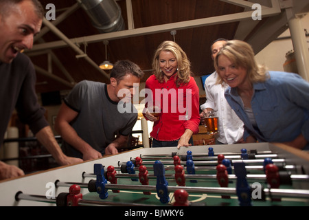 Gli amici a giocare a biliardino Foto Stock