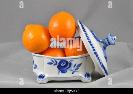 Quattro le arance nel vaso di porcellana, still life , Tabella di sommità della composizione artistica, impostare Foto Stock