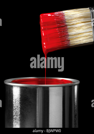 Pennello immerso in vernice rossa isolato su sfondo nero Foto Stock