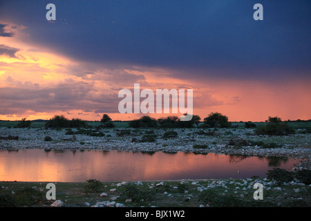 Drammatica colorato Cielo e nubi al tramonto riflesso in waterhole Foto Stock