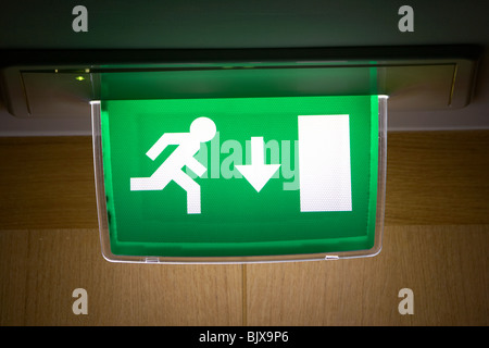 In stile Europeo illuminato in esecuzione di emergenza UOMO FIRE EXIT segno Foto Stock