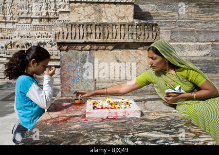 Donna indiana rendendo un fiore che offre. Shree Jagdish Temple. Udaipur. Il Rajasthan. India Foto Stock