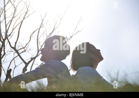 Coppia giovane seduto di schiena Foto Stock