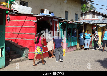 Embera ragazza (nel mantello giallo) e le bancarelle del mercato nella strada principale di La Palma , Darien , Panama Foto Stock