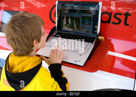 Ragazzo di 7 anni cerca computer portatile presso fornitori booth. Cinco de Mayo Fiesta St Paul Minnesota USA Foto Stock