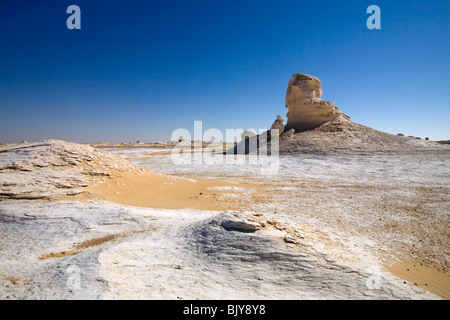 Inselburgs con circostante sabbia ondulata, in condizioni di luce solare intensa,Bianco Deserto, Farafra, Egitto, Nord Africa Foto Stock