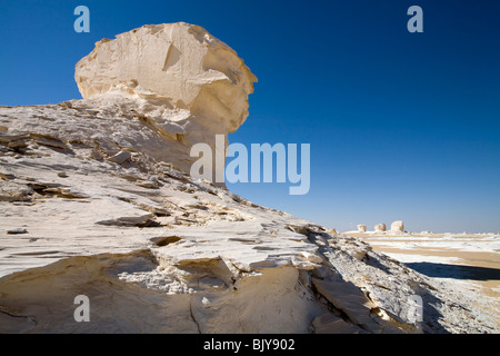 Inselburgs con circostante sabbia ondulata, in condizioni di luce solare intensa,Bianco Deserto, Farafra, Egitto, Nord Africa Foto Stock