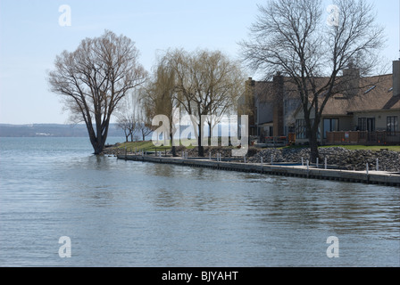 Alloggiamento e alberi acqua di confine accesso al lago Canandaigua NY. Inizio della primavera gemme sugli alberi. Foto Stock