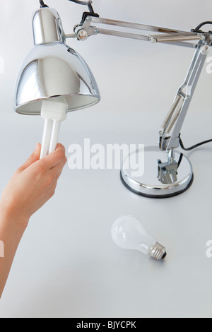 La mano di una donna che mantiene le lampadine della luce Foto Stock